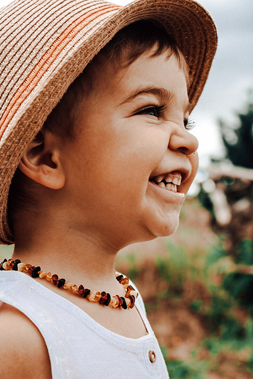 bébé avec collier d'ambre cognac